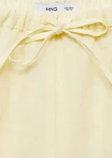Pantalón de lino color amarillo claro, de corte recto y tiro medio, con cintura elástica ajustable con lazo.