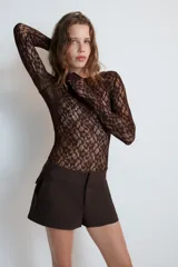 Bermudas de tiro medio color negro, con cintura ancha, bolsillos delanteros y cierre frontal con cremallera y ganchos metálicos.
