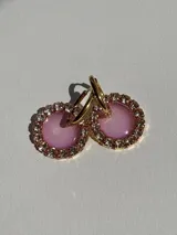 Aros tipo argolla dorados con dije redondo de resina color lila y borde de strass.