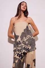 Top strapless color beige con estampado de hojas negras.