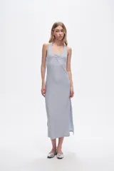 Vestido midi de corte ajustado, con escote profundo tipo halter y detalle de frunce en el centro del pecho. Presenta aberturas laterales en el ruedo.