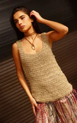 Top tejido de punto en color beige, con escote cuadrado y tirantes anchos. Presenta un diseño de textura rústica y un ruedo decorado con flecos largos en tonos azul, rojo y plateado.