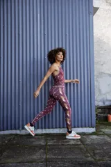 Calza larga de lycra color bordó con estampado de figuras geométricas en tonos rosados.