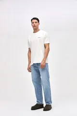 Remera de algodón lavado con textura suave, de manga corta y calce relajado. Presenta un diseño gráfico minimalista en el pecho y un estampado artístico en la espalda.