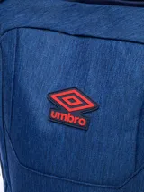 Mochila Umbro color azul con detalles en rojo, fabricada en poliéster. Cuenta con un compartimento principal con cierre, un bolsillo frontal vertical con cierre, un bolsillo frontal horizontal con cierre y dos bolsillos laterales de malla. El logo de Umbro está presente en la parte superior y en la parte inferior de la mochila.