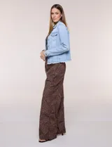 Campera de jean Baccini de color celeste claro, con cuello solapa, cierre frontal con botones metálicos, bolsillos en el pecho y ruedo con terminación desflecada.