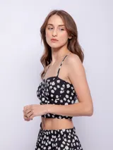 Top negro con estampado de flores blancas, breteles finos y escote corazón con detalle de puntilla.