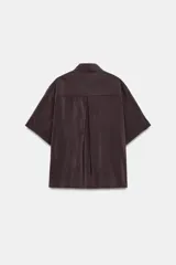 Camisa de cuello solapa y manga corta con dobladillo, presenta bolsillos de plastrón en el frente, bajo asimétrico y cierre frontal con botones ocultos.