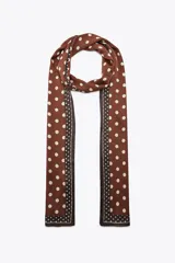 Pañuelo largo de satén con estampado de lunares grandes en color marrón y crema, con bordes decorados con una franja de lunares más pequeños y líneas a contraste.