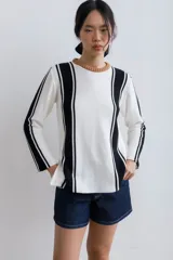 Sweater de punto negro con rayas verticales blancas y cuello redondo color marrón.