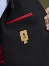 Blazer negro de corte clásico con dos botones frontales, solapa de muesca y bolsillos laterales.