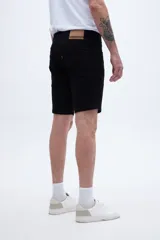 Bermuda de jean negra de calce clásico, pierna recta y tiro medio.