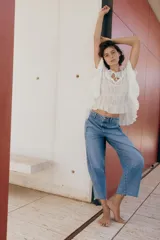 Jeans de tiro medio con pernera holgada tipo barrel que se estrecha hacia el tobillo, acabado con bajo sin costura, bolsillos delanteros y bolsillos de plastrón en la espalda. Cierre frontal con cremallera y botón.