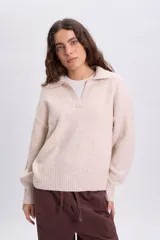 Buzo de punto beige con cuello polo y mangas largas, confeccionado con mezcla de lana y elastano.