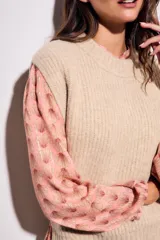 Chaleco de punto color beige con cuello alto y sisas amplias.