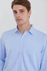 Camisa celeste de vestir, de manga larga, con cuello clásico y bolsillo en el pecho.