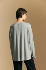 Remera de manga larga con silueta relajada y caída fluida, confeccionada en tejido suave con cuello redondo y aberturas laterales en el ruedo.