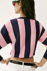 Sweater de punto con diseño de rayas verticales anchas en color azul marino y rosado, cuello redondo y mangas largas con puños ajustados.