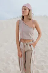 Pantalón de lino a rayas horizontales en tonos naranja, rosa y gris.