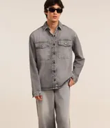 Pantalon baggy de jean gris con efecto deslavado, tiro medio, cierre con boton y cremallera, trabillas para cinturon y bolsillos delanteros y traseros.