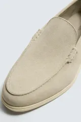Mocasín casual de hombre fabricado en piel con acabado de serraje, diseño de corte liso con detalle de bordón y suela fina a tono.