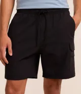Bermuda cargo masculina confeccionada en poliamida, de color negro, con cintura elástica, cordón ajustable y bolsillos laterales cargo.