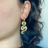 Par de aros colgantes plateados con forma tribal.