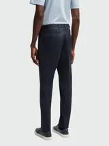 Pantalones de vestir de corte recto y diseño clásico, confeccionados en tejido liso de color azul oscuro. Presentan cierre frontal con cremallera y botón, trabillas para cinturón y bolsillos laterales.