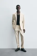 Blazer de corte regular fit confeccionado en tejido con lana. Presenta cuello con solapas de muesca, cierre frontal de un botón, bolsillos de vivo en el pecho y en la cadera, y aberturas en la espalda.