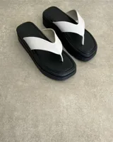 Ojota de plataforma color negro con tira ancha en forma de V de cuero vegano blanco.