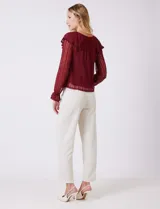 Blusa de encaje color beige, marca Cupio, con cuello a la base y escote en V con lazo de ajuste. Presenta una sobrecapa de encaje con aplique de puntilla y mangas largas de encaje floral translúcido, terminadas en puños elásticos con volado. Incluye forro interno a tono.