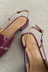 Sandalias de cuero color negro, estilo romanas con tiras entrelazadas en la parte delantera, talón descubierto y tira ajustable con hebilla metálica.