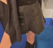 Short pollera de diseño irregular que combina paneles de cuero sintético liso con paneles de tejido de punto con brillos. Presenta bordes desflecados y una estructura asimétrica.