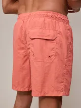 Short de baño tipo volley, color azul piedra con efecto lavado, cintura elástica con cordón ajustable y bolsillos laterales.