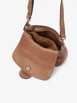 Bolso bandolera de cuero vacuno lavado color marrón, con solapa y asa de hombro extraíble decoradas con tachuelas y corte láser. Cuenta con cierre de cremallera, bandolera regulable y desmontable, bolsillos externos e internos y forro de algodón.