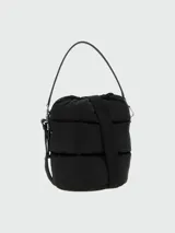 Cartera tipo bucket Moncler modelo Caradoc, de diseño acolchado y color negro, con cierre superior fruncido mediante cordón ajustable, asa superior de hombro y detalle del logo metálico de la marca en el frente.