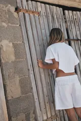 Camiseta gris con efecto lavado, cuello redondo con ribete y mangas cortas tipo capa.