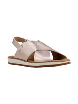 Sandalias de cuero metalizado en tono rosado, con tiras cruzadas en el empeine, tira ajustable en el talón y suela plana con plataforma baja y base dentada.