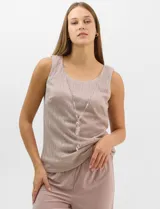 Conjunto de tres piezas compuesto por una musculosa recta, un cardigan liviano de frente abierto con mangas 3/4 y un pantalón de seda fría. La musculosa y el cardigan están confeccionados en tejido plisado con hilos metalizados tornasolados. Incluye collar removible y forro interno a tono.