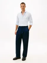 Camisa de Tommy Hilfiger confeccionada en popelín de puro algodón regenerativo con diseño de rayas bengal en tonos celeste y blanco. Cuenta con cuello camisero, cierre frontal de botones y el logo de la marca bordado en el pecho.