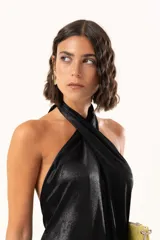 Vestido midi de satén color negro, con escote halter cruzado y ruedo terminado en flecos largos.