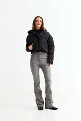 Campera puffer corta de color negro, con capucha, cierre frontal con cremallera y solapa con botones a presión.