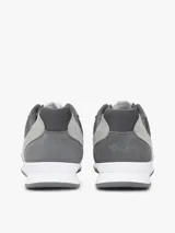 Zapatillas tipo runner de Tommy Hilfiger en tonos gris y gris oscuro, con detalles en blanco. Confeccionadas en una mezcla de cuero y textil, cuentan con pasadores blancos, suela de goma blanca y diseño lateral característico de la marca.
