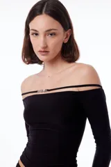 Top negro con cuello bote, hombros descubiertos y mangas largas.