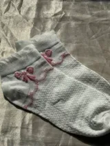 Medias blancas de tejido texturizado con rombos en relieve y borde superior con volados.