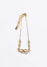 Pulsera de cadena fina con baño de oro 18k sobre base de plata 925, con diseño central de símbolo de infinito decorado con zirconias y puntos de luz engastados a lo largo de la cadena.