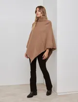 Poncho tejido color crema, con cuello polera y diseño trenzado diagonal en el frente. Presenta un corte asimétrico en el ruedo.