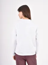 Buzo de cuello redondo y manga larga, color gris jaspeado con estampado de dos estrellas en tono oscuro con efecto desgastado.