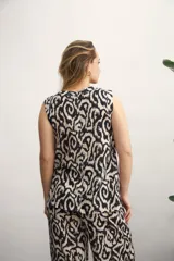 Blusa sin mangas con estampado abstracto en tonos verde y beige.