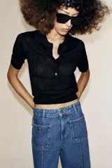 Jeans culotte de tiro alto, color azul, con pernera ancha, nervios marcados en el delantero y bolsillos de parche con botones metálicos. Cuenta con cierre frontal de cremallera y botón metálico.